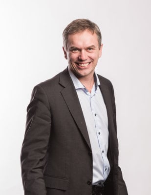 Smilende mann i skjorte og dressjakke